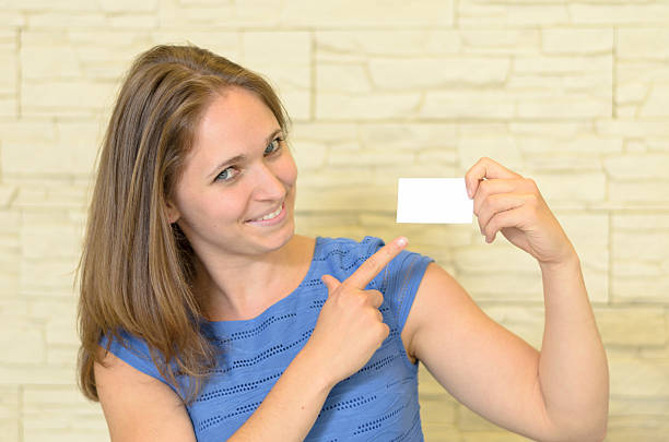 istock Cheerful Young Woman Holding a Small Blank Card 479526546