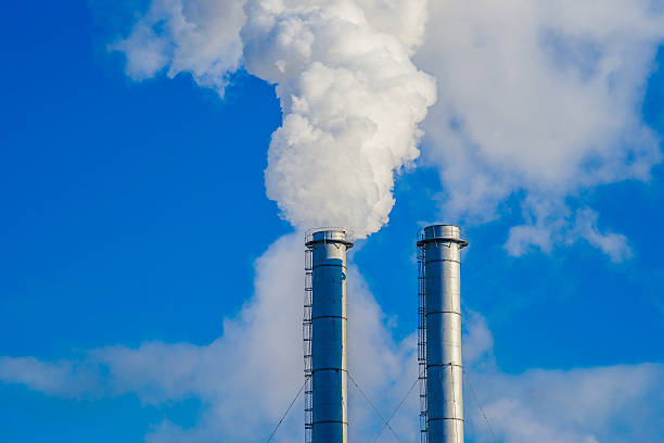 istock Two industrial metallic chimneys emitting the white smoke 479528404