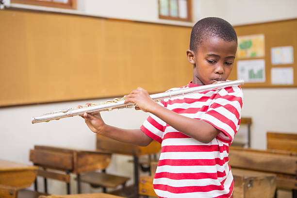 istock Cute pupil playing flute in classroom 479532560