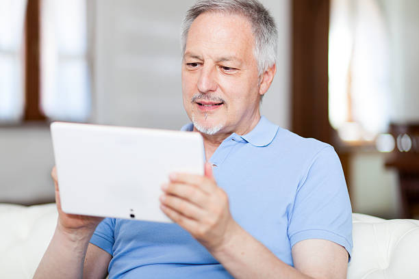 istock Mature man in sofa websurfing with tablet 479532878