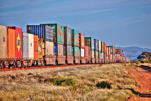 treno merci con container multicolori pila di entroterra brani - entroterra foto e immagini stock