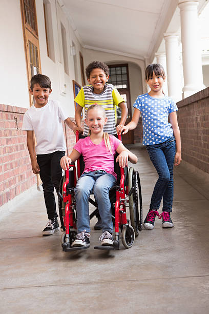 istock Cute disabled pupil smiling at camera with her friends 479535910