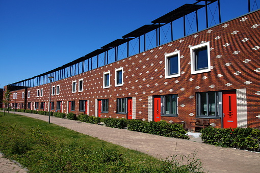 Modern houses in a row in a Dutch suburban city street (Almere). Row building of houses is the traditional way of building homes in the Netherlands.