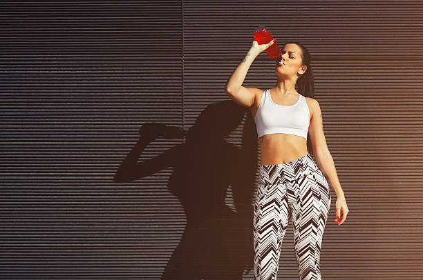 istock Sportswoman drinking energy drink against blank copy space 479536512