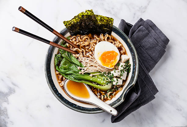 Miso Ramen noodles with egg, enoki and pak choi Miso Ramen Asian noodles with egg, enoki and pak choi cabbage in bowl on white marble background nori stock pictures, royalty-free photos & images