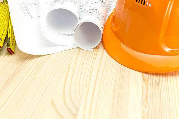 istock safety helmet with blueprints on wooden desk 479542262