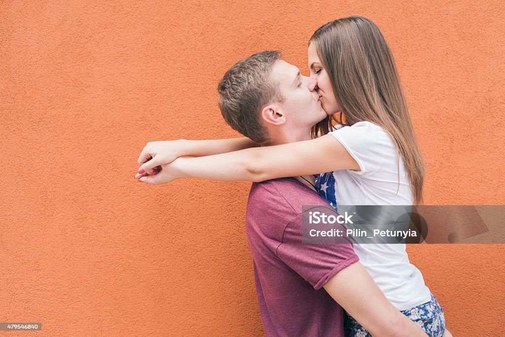 Happy And Funny Couple Kissing At Red Wall Background Stock Photo -  Download Image Now - iStock