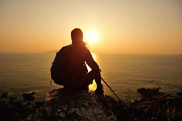 istock woman hiker sit on rock face the sunrise 479547207