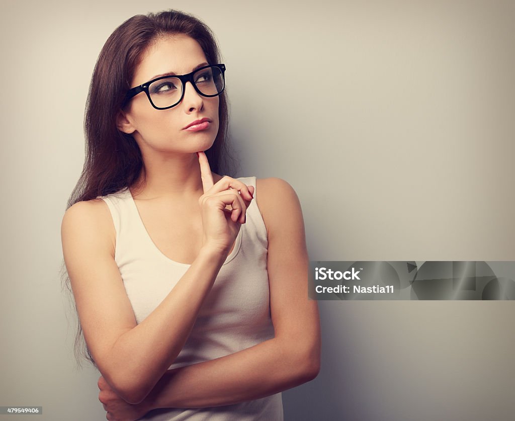 Serious fun thinking young woman looking up Serious fun thinking young woman looking up on empty copy space. Vintage portrait Disbelief Stock Photo