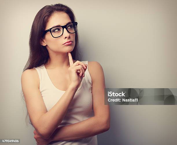 Serious Fun Thinking Young Woman Looking Up Stock Photo - Download Image Now - Disbelief, Facial Expression, Suspicion