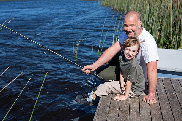 istock Happy man fishing with his son 479552112