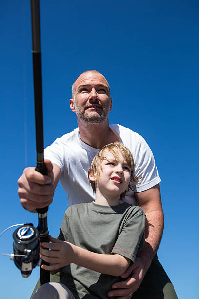 istock Happy man fishing with his son 479552118