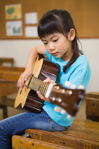 istock Cute pupil playing the guitar 479554518