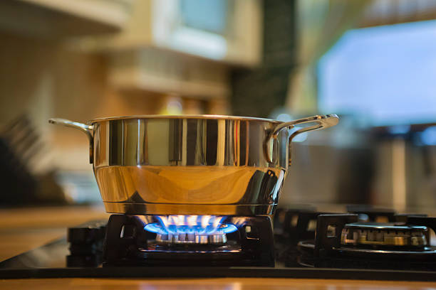 acero inoxidable cacerola sobre gas estufa de dos quemadores. - gas ranges fotografías e imágenes de stock