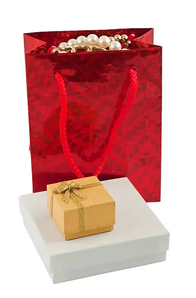Red giftbag with jewelry and two boxes isolated on white