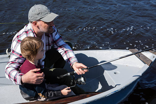 istock Happy man fishing with his son 479557758