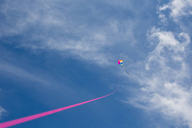 istock Colorful kite with pink kitestring under a blue cloudy sky 479560490