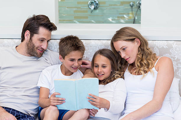 istock Happy family on the bed reading book 479560646
