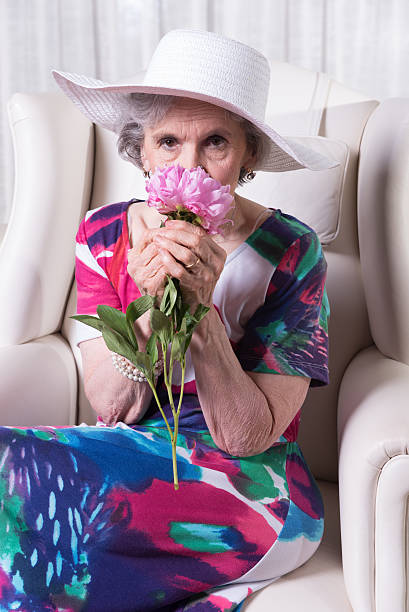 istock active female senior smelling a flower 479561254