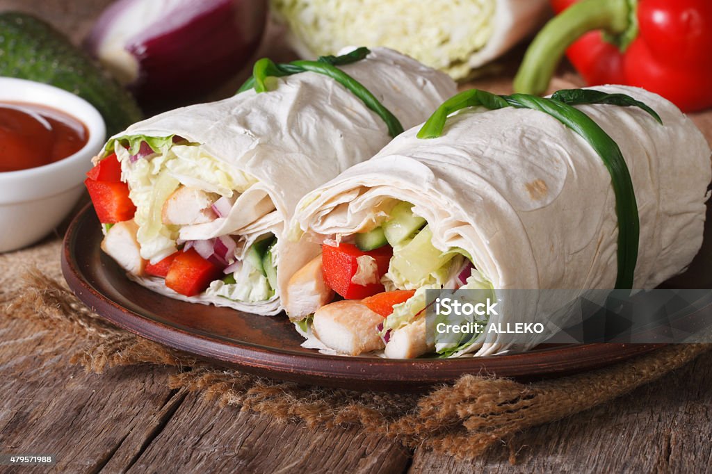 Burrito with chicken and vegetables horizontal Burrito with chicken and vegetables close up on a plate. horizontal 2015 Stock Photo