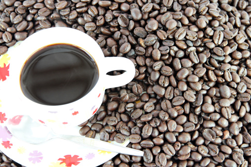 Coffee beans and white Cup of background.