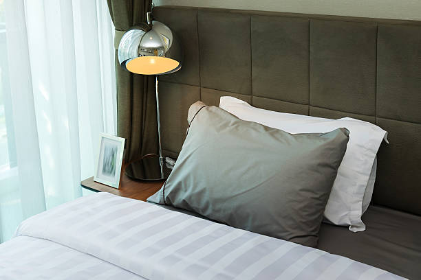 istock metal desk lamp and grey pillow on bed 479572700
