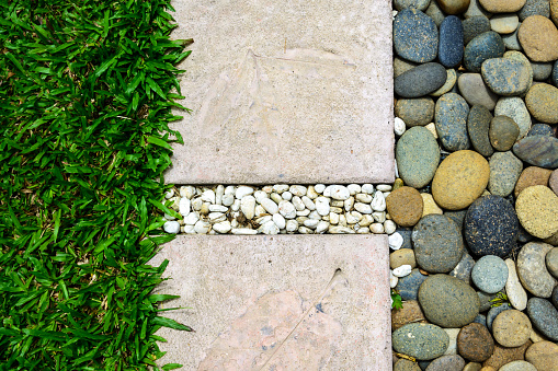 Ornament Stone footpath with pebble and grass in the garden