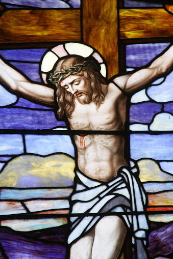 The crucifixion of Jesus Christ is portrayed in this stained glass panel in an old church.