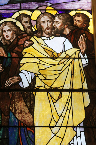 The betrayal of Jesus by Judas is depicted in this stained glass panel.