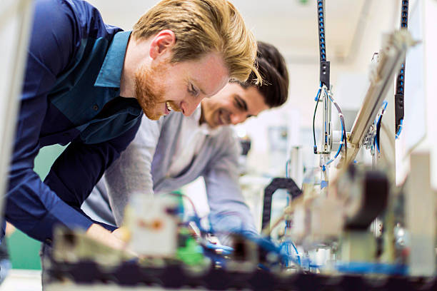 dos joven atractivo los ingenieros trabajando en componentes de electrónica - technology computer chip industry electrical equipment fotografías e imágenes de stock