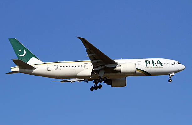 Pakistan International Airlines Boeing 777-200LR Manchester, England, United Kingdom - March 11, 2014. Pakistan International Airlines Boeing 777-200 on approach to land. lahore pakistan photos stock pictures, royalty-free photos & images