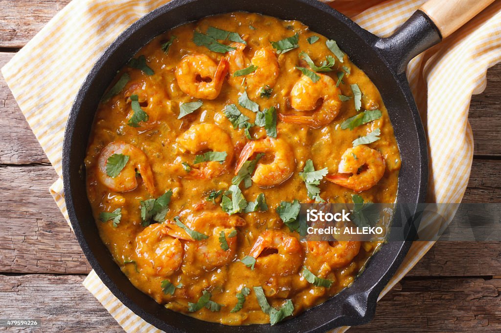 Shrimp in curry sauce in pan close-up horizontal top view Shrimp in curry sauce in a pan close-up. horizontal view from above 2015 Stock Photo