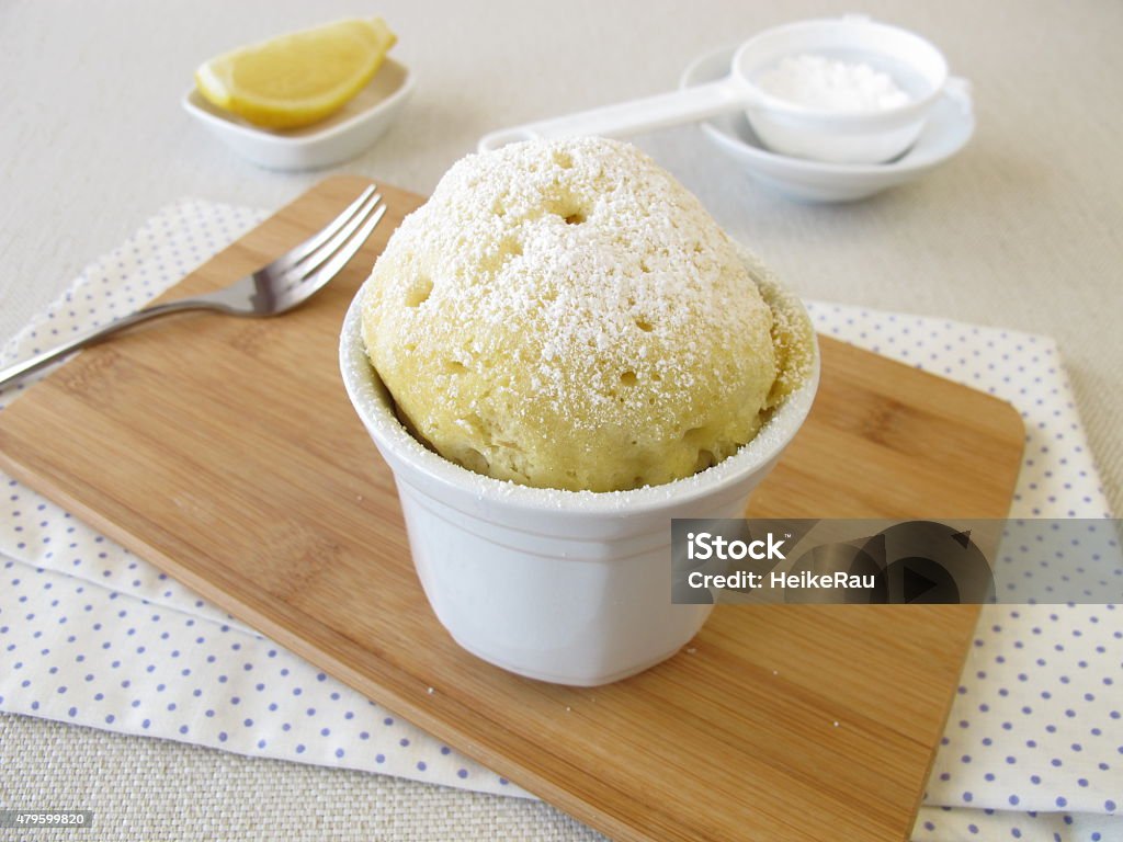 Lemons mug cake with powdered sugar Lemons mug cake with powdered sugar - Zitronen Mug Cake mit Puderzucker Microwave Stock Photo