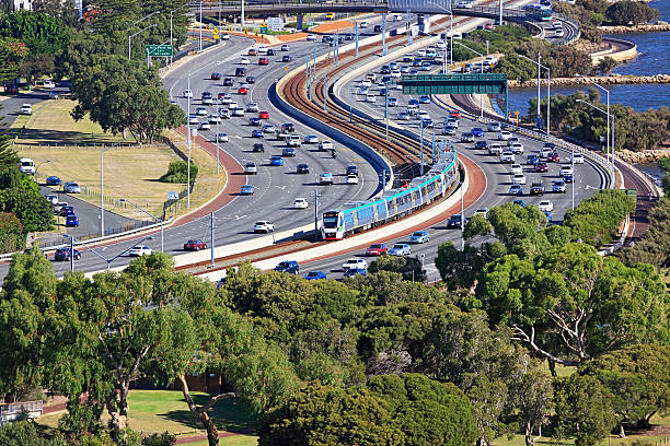 istock City transport: electric train travels down middle of busy freeway 479602648