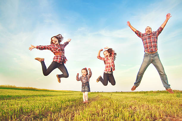 istock family jumping in the field. 479607714