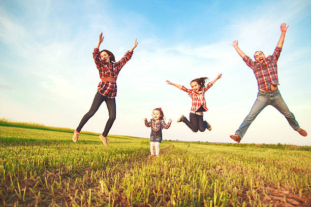 istock family jumping in the field. 479607752