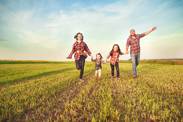 family jumping in the field.family running in the field.