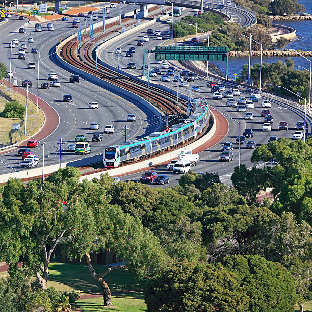 istock City transport: Metro train travels down middle of freeway 479609298
