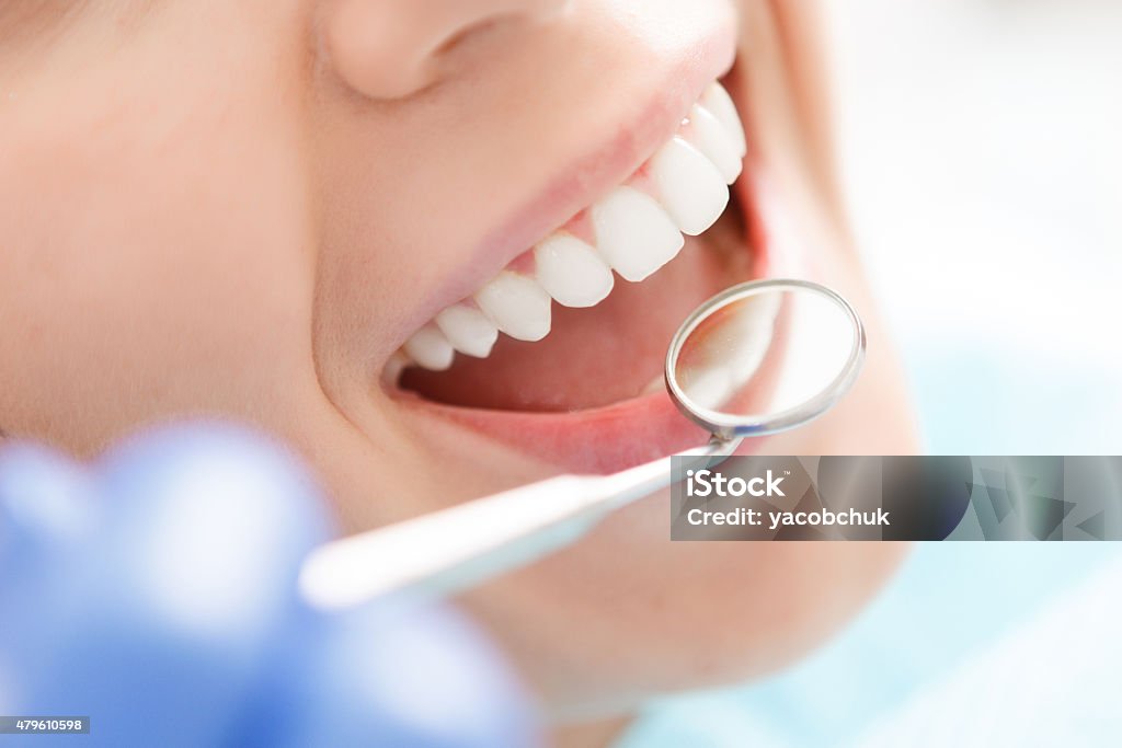 Close-up of woman having her teeth examined Doing professionally. Smiling pretty woman is having her teeth examined by dentist in clinic. Dentist Stock Photo