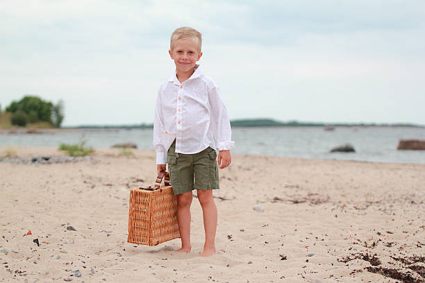 Boy on the beach with a picnic basket