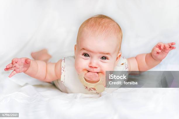 Baby Girl On Stomach With Hands Spread Apart And Teethers Stock Photo - Download Image Now