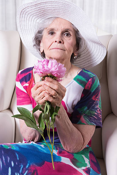 istock active female senior smelling a flower 479613914