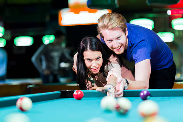 istock Young handsome man and woman flirting while playing snooker 479618428