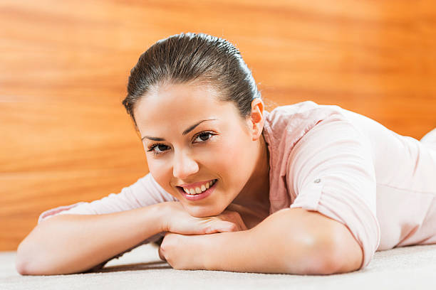 Portrait of beautiful woman laying on arms and looking at camera