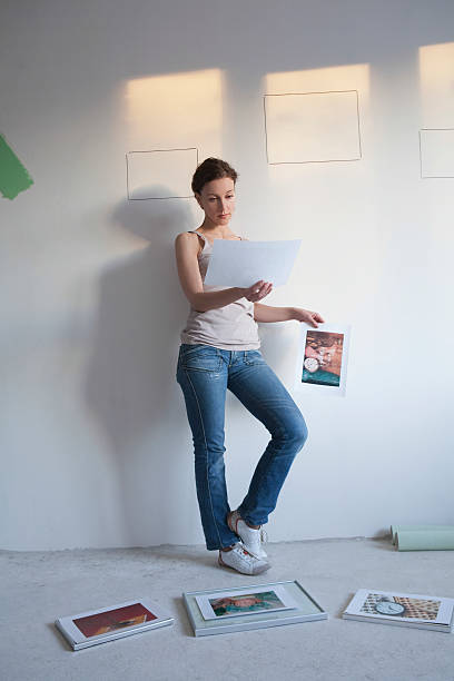 istock Woman Decides On Pictures To Mount Wall 479624949