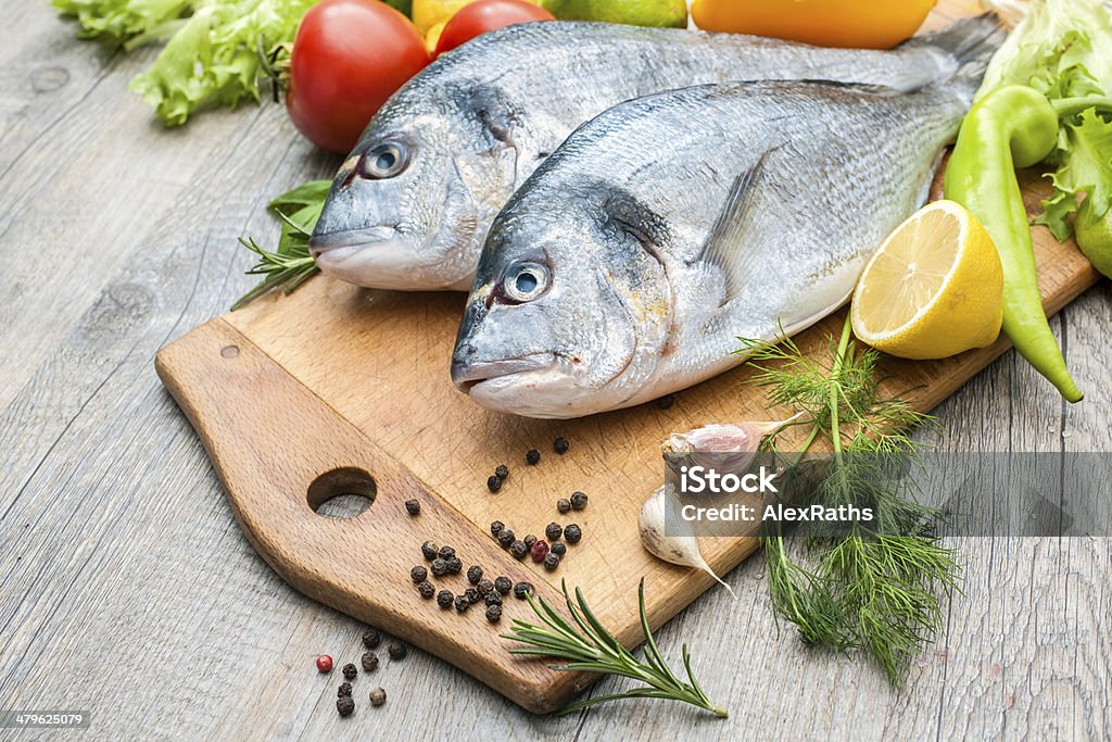 Fresh raw fish gilthead bream Fresh raw fish gilthead bream  a cutting board Fish Stock Photo