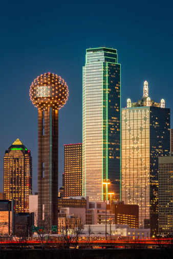 Dallas cityscape with the Bank of America and Reunion Tower glowing in orange from the last sunrays of the day