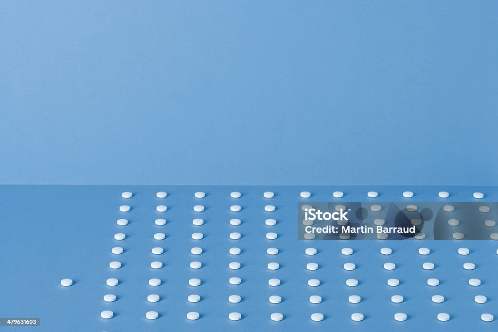 Pills lined up in rows with one beside  Abundance Stock Photo