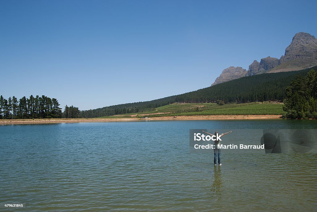 Woman standing on water with arms up  Full Length Stock Photo