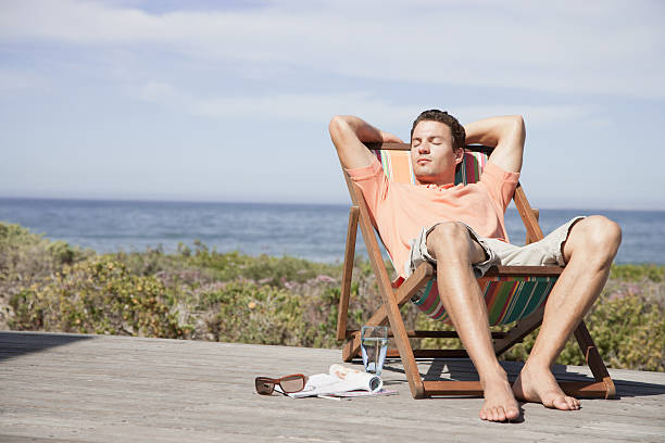 Man relaxing in a lounge chair  deck chair stock pictures, royalty-free photos & images